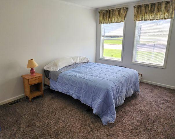 305 4th Ave SW, Milltown, WI 54858 - carpeted bedroom featuring multiple windows, ornamental molding, and baseboards