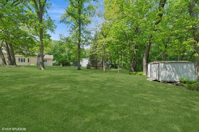 28075 Zuni St NW, Isanti, MN 55040 - view of grassy yard featuring a storage unit and an outbuilding