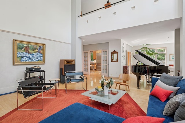 living area featuring wood finished floors and a towering ceiling