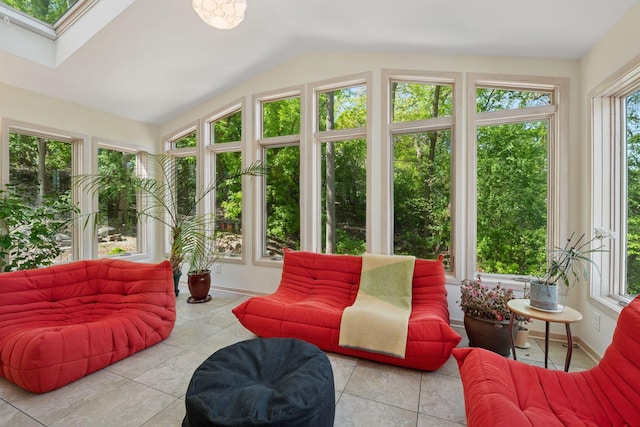 sunroom / solarium with lofted ceiling, a skylight, and tile patterned flooring
