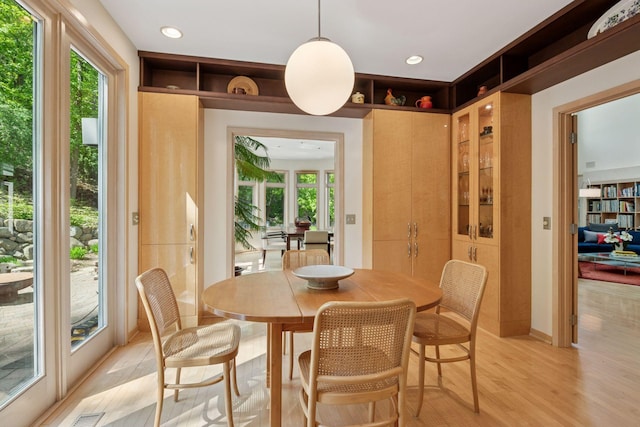 dining space with light wood-style flooring and recessed lighting