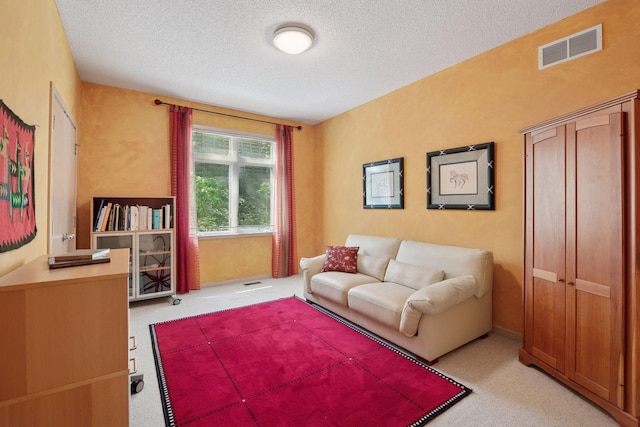 living area featuring a textured ceiling and light carpet
