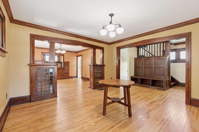 unfurnished dining area with baseboards, a chandelier, light wood finished floors, ornamental molding, and stairs