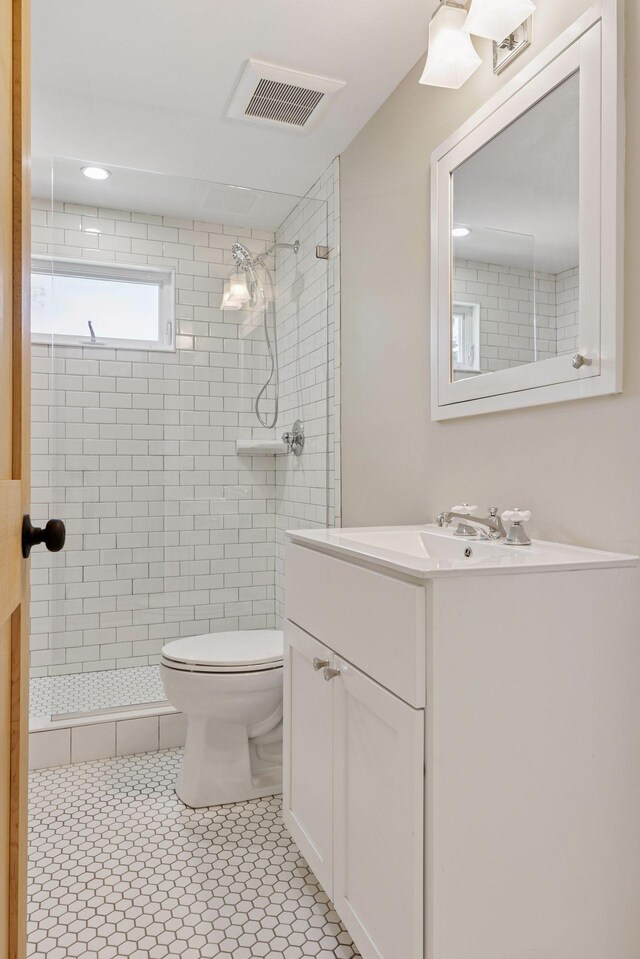 full bathroom featuring a shower stall, toilet, and vanity