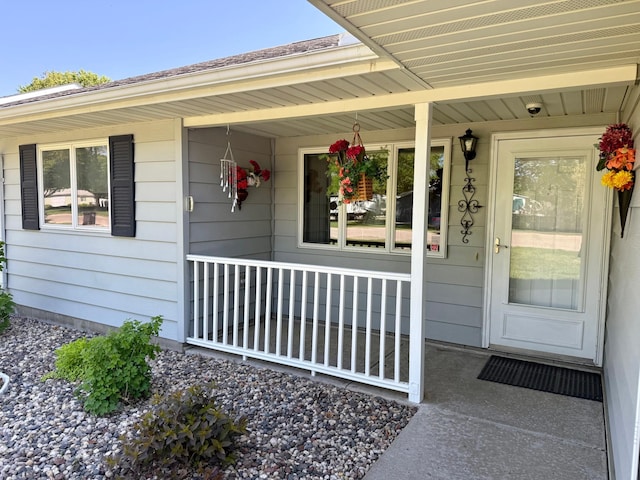 view of exterior entry with covered porch and a surveillance system