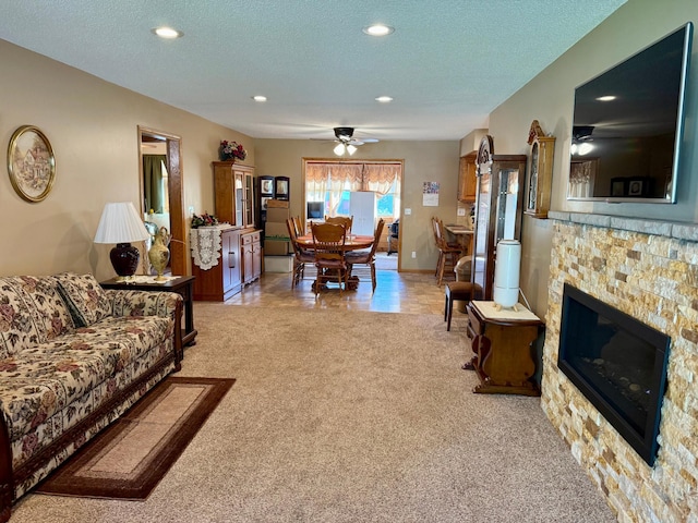 living room with light colored carpet, recessed lighting, a textured ceiling, a fireplace, and a ceiling fan