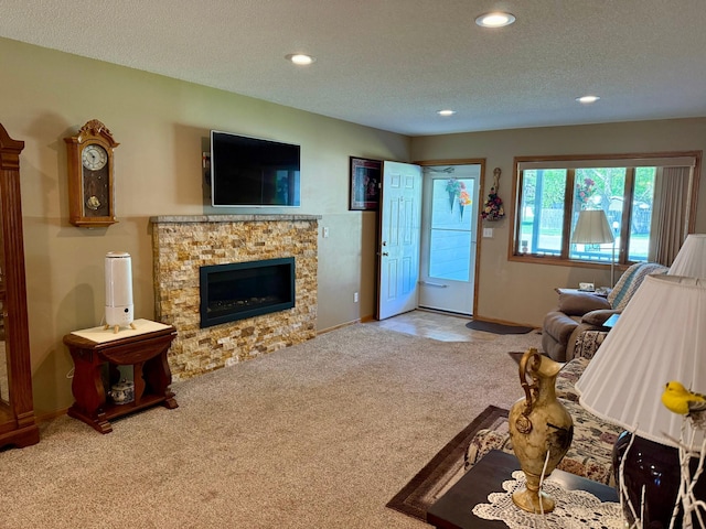 carpeted living room with recessed lighting, a textured ceiling, baseboards, and a fireplace