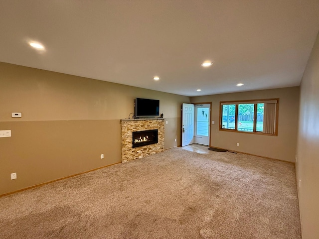 2705 6th St SW, Willmar, MN 56201 - unfurnished living room with carpet floors, recessed lighting, and a lit fireplace