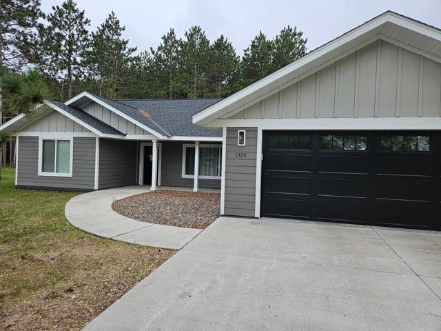 ranch-style home featuring board and batten siding, driveway, and an attached garage