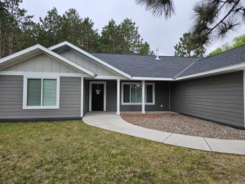 single story home featuring board and batten siding and a front yard