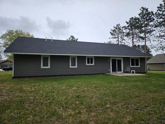 rear view of house featuring a patio and a lawn