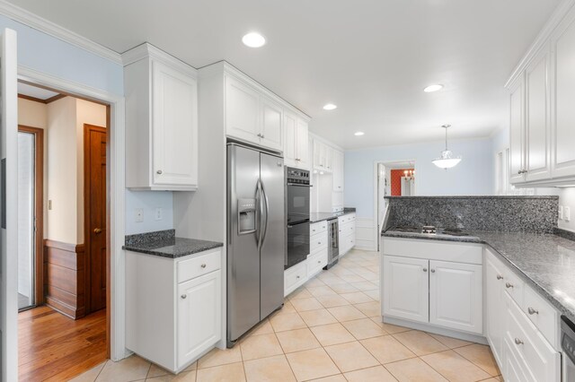 1429 20th St SW, Rochester, MN 55902 - kitchen with stainless steel appliances, white cabinets, crown molding, a peninsula, and decorative light fixtures