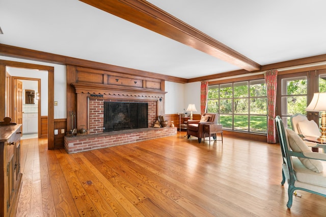 1429 20th St SW, Rochester, MN 55902 - living area featuring beam ceiling, light wood finished floors, a fireplace, a wainscoted wall, and healthy amount of natural light