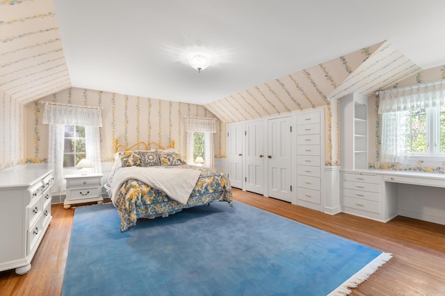 1429 20th St SW, Rochester, MN 55902 - bedroom with wallpapered walls, lofted ceiling, multiple windows, and light wood-style flooring