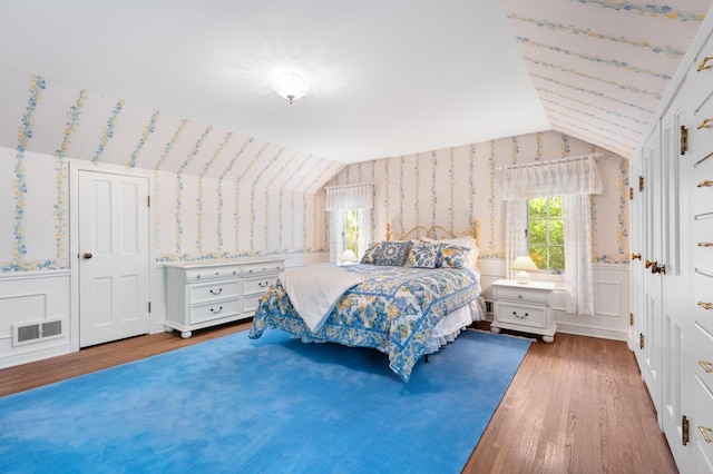 1429 20th St SW, Rochester, MN 55902 - bedroom with wallpapered walls, vaulted ceiling, wainscoting, and wood finished floors