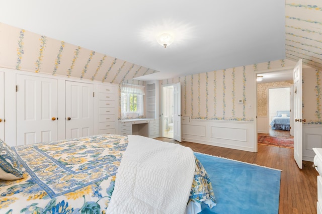 1429 20th St SW, Rochester, MN 55902 - bedroom with a wainscoted wall, wood finished floors, wallpapered walls, ensuite bathroom, and a decorative wall