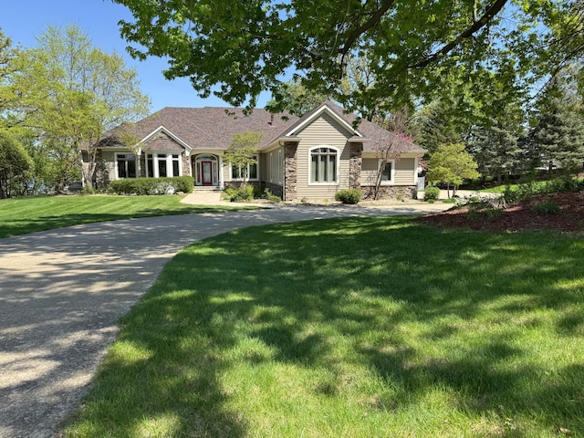 ranch-style house featuring a front yard and stone siding