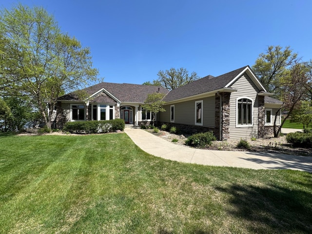 ranch-style home featuring stone siding and a front yard
