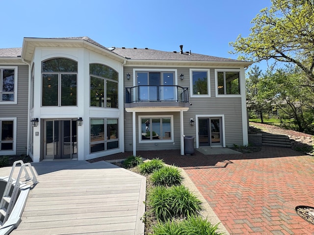 back of property featuring french doors, a balcony, and a patio area