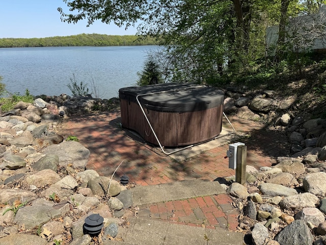 view of yard featuring a hot tub and a water view