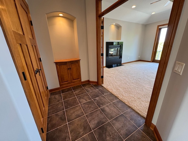 hall with dark colored carpet, baseboards, recessed lighting, and dark tile patterned flooring