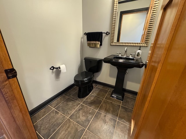half bath featuring toilet, tile patterned floors, and baseboards