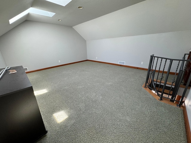 bonus room featuring a skylight, vaulted ceiling, baseboards, and carpet flooring