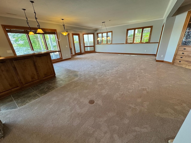 unfurnished living room with ornamental molding, dark colored carpet, baseboards, and plenty of natural light