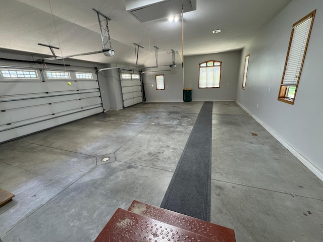garage featuring a garage door opener and baseboards