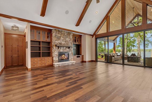 17488 Alexander Ct, Cold Spring, MN 56320 - unfurnished living room featuring high vaulted ceiling, a stone fireplace, wood finished floors, beam ceiling, and baseboards