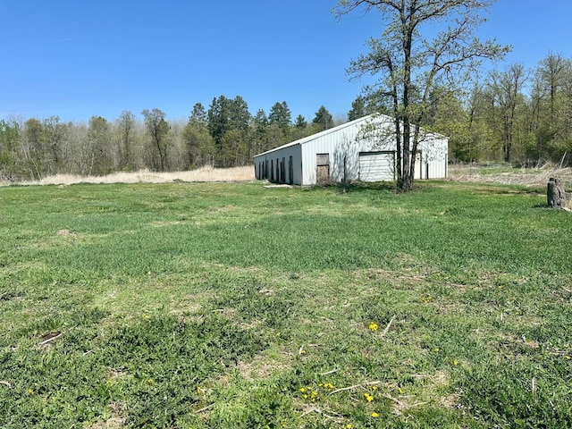 view of grassy yard with an outbuilding and a garage