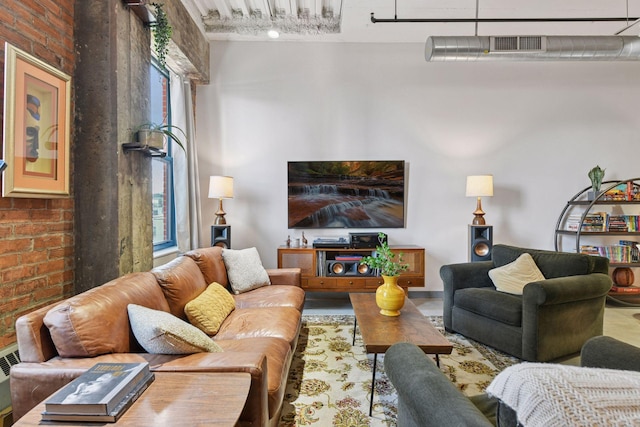 living area featuring brick wall