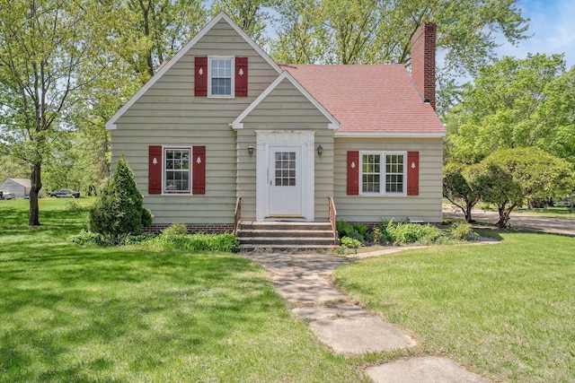 view of front facade with a front lawn, a chimney, and roof with shingles