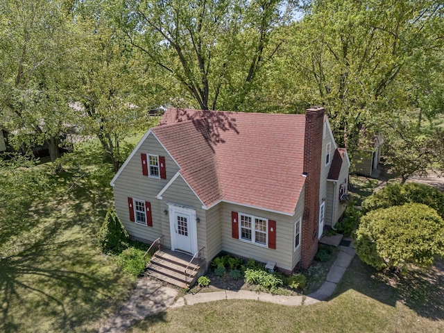 view of front of property with a shingled roof and a chimney