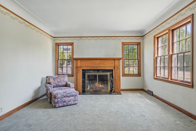 living room featuring carpet floors, a high end fireplace, baseboards, and ornamental molding