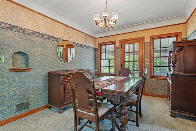 dining area featuring a chandelier, wallpapered walls, carpet floors, baseboards, and crown molding