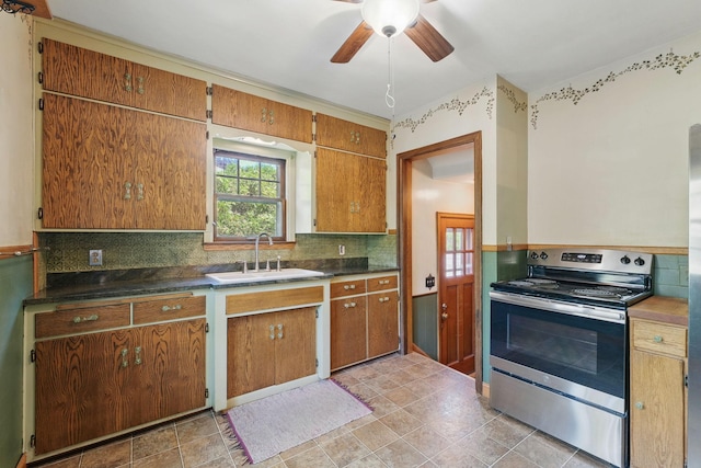 kitchen featuring stainless steel range with electric stovetop, a sink, a ceiling fan, tasteful backsplash, and brown cabinets