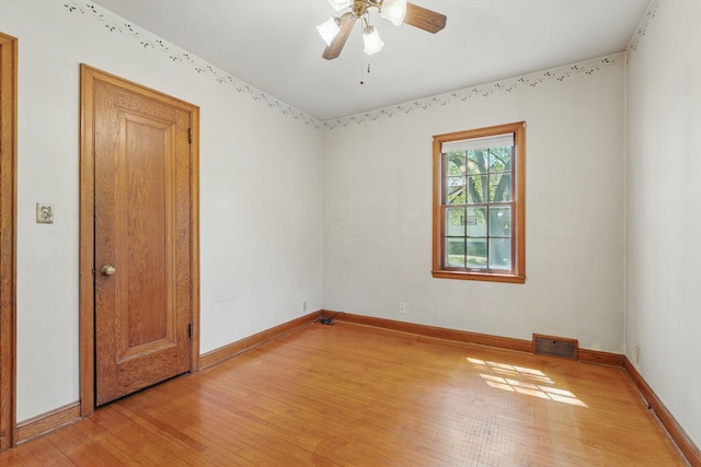 unfurnished room featuring light wood-type flooring, baseboards, and a ceiling fan