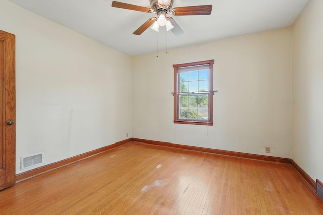 spare room with light wood finished floors, baseboards, and a ceiling fan