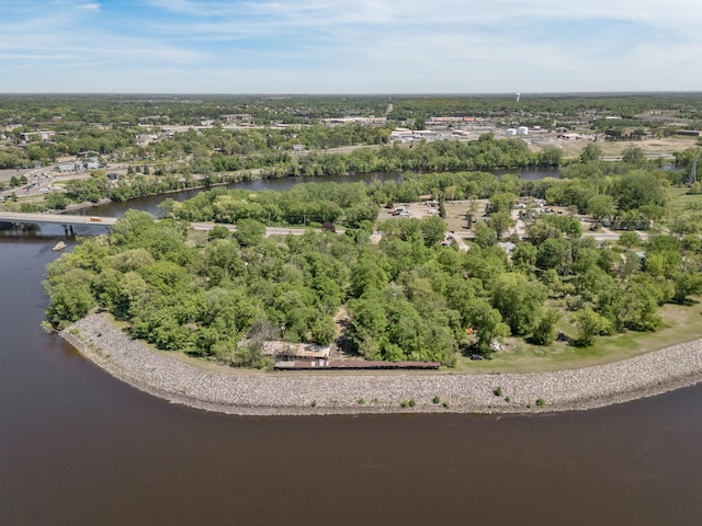 drone / aerial view of a large body of water, a notable bridge, and a tree filled landscape