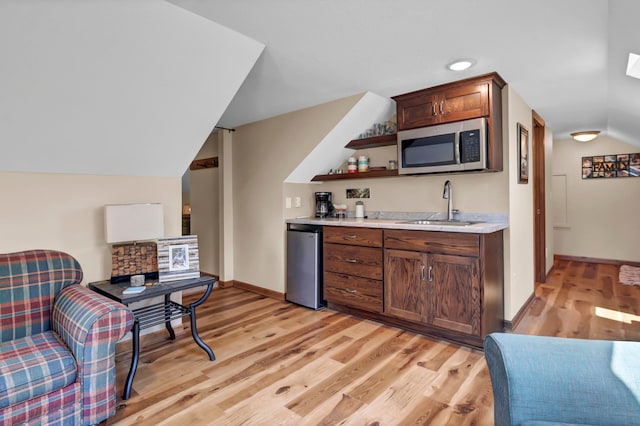 19336 Koetter Ct, Richmond, MN 56368 - indoor wet bar featuring appliances with stainless steel finishes, vaulted ceiling, light wood finished floors, and baseboards