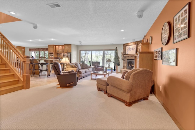19336 Koetter Ct, Richmond, MN 56368 - living area with light colored carpet, plenty of natural light, stairway, a stone fireplace, and a textured ceiling