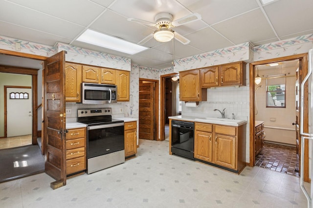716 4th St NE, Minneapolis, MN 55413 - kitchen with stainless steel appliances, a sink, ceiling fan, wallpapered walls, and light countertops