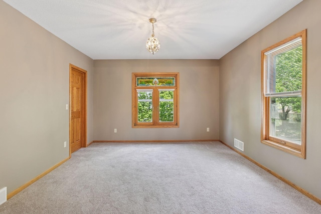 716 4th St NE, Minneapolis, MN 55413 - spare room with healthy amount of natural light, light colored carpet, a chandelier, and baseboards