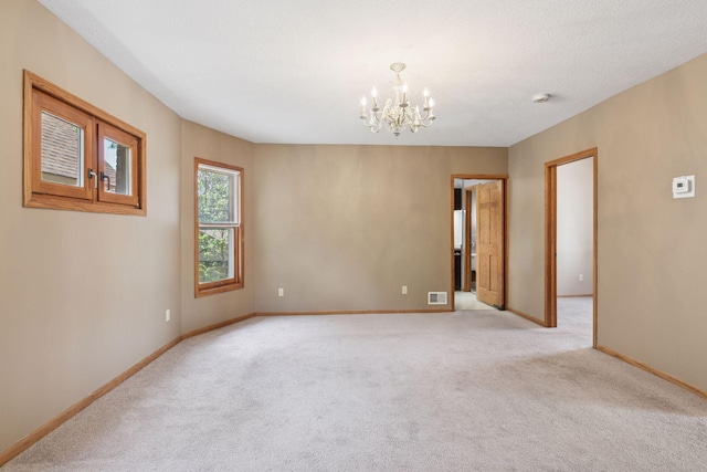 716 4th St NE, Minneapolis, MN 55413 - spare room with a chandelier, light colored carpet, and baseboards