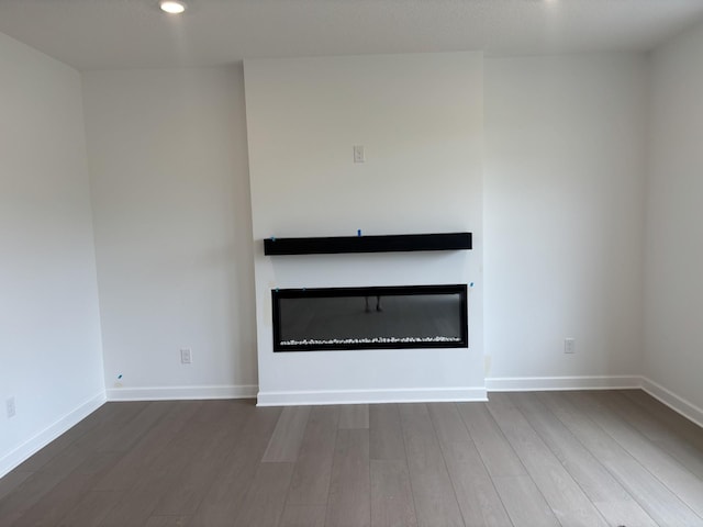 7370 184th St W, Lakeville, MN 55044 - unfurnished living room featuring a glass covered fireplace, wood finished floors, and recessed lighting