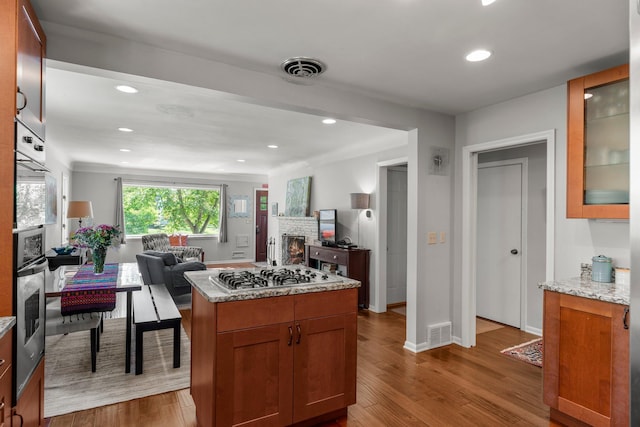 2532 Upton Ave S, Minneapolis, MN 55405 - kitchen featuring stainless steel appliances, open floor plan, a stone fireplace, wood finished floors, and recessed lighting