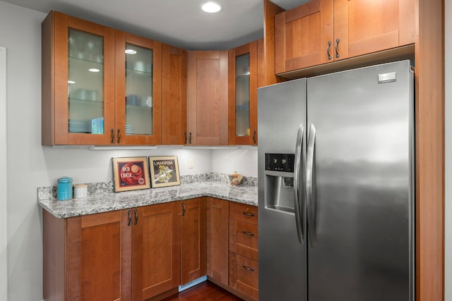 2532 Upton Ave S, Minneapolis, MN 55405 - kitchen featuring stainless steel fridge, brown cabinetry, light stone countertops, glass insert cabinets, and recessed lighting