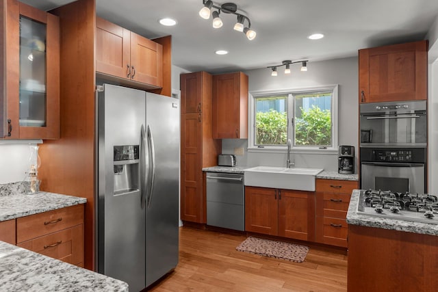 2532 Upton Ave S, Minneapolis, MN 55405 - kitchen featuring stainless steel appliances, a sink, brown cabinets, light wood-style flooring, and recessed lighting