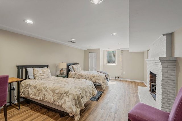 2532 Upton Ave S, Minneapolis, MN 55405 - bedroom featuring light wood-style floors, a brick fireplace, baseboards, and recessed lighting